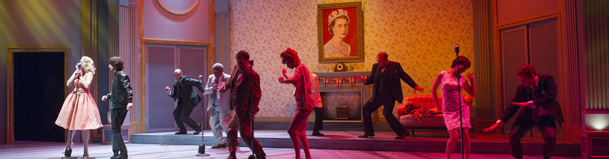 Photo of a blonde onstage singing into a mic while cast members behind are dancing the twist.