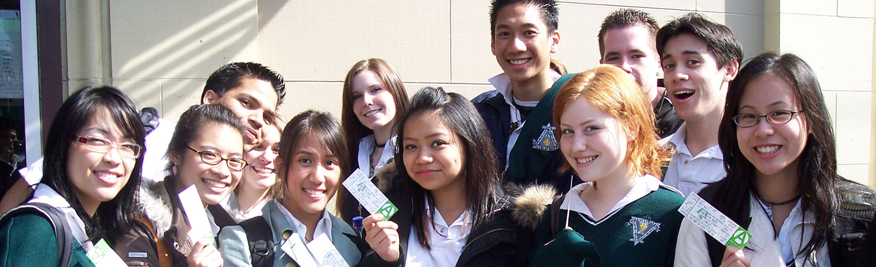 Photo of a group of smiling students holding up Arts Club Theatre Company show tickets.