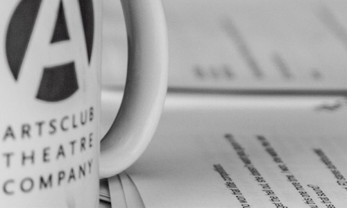 Close-up photo of a white Arts Club coffee mug and script.