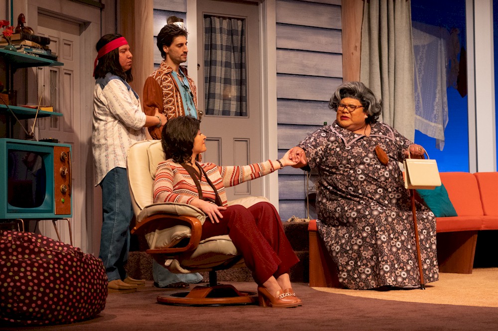 Braiden Houle, Aidan Correia, Cheri Maracle, and Marshall Vielle in <em>Father Tartuffe: An Indigenous Misadventure</em>, 2024: set design by Ted Roberts; costume design by Jolane Houle; lighting design by Jillian White; projection design by Bracken Hanuse Corlett; photo by Moonrider Productions for the Arts Club Theatre Company